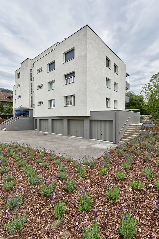 MFH Kirchfeldstrasse – Frontansicht nach Sanierung, Garagen und Lavendelbeet