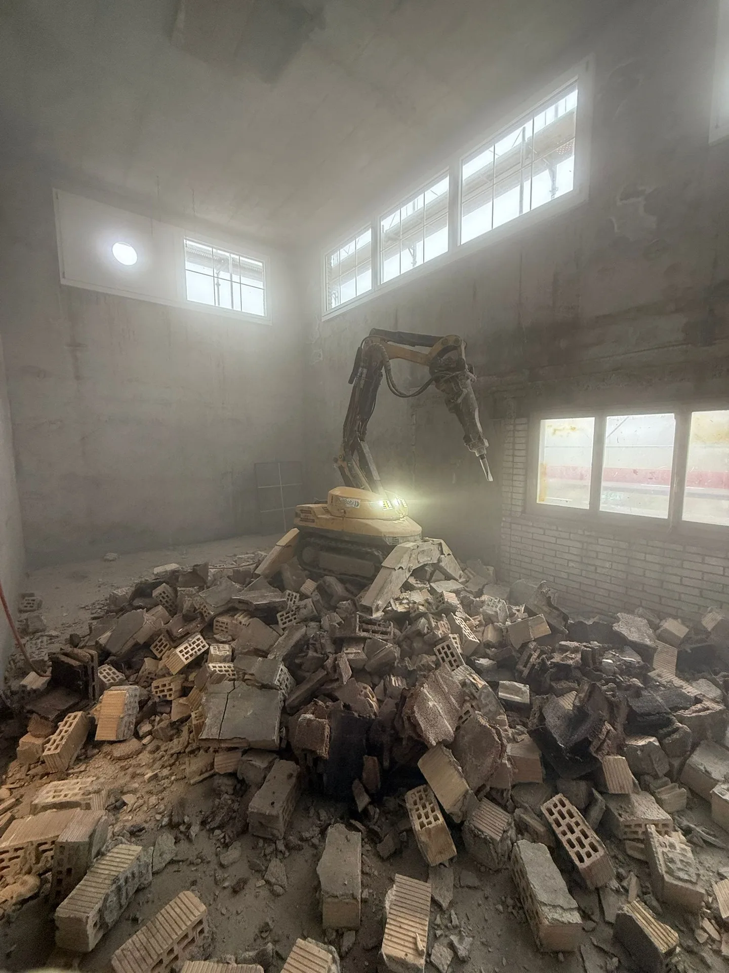 Innenabbruch – Minibagger beim Rückbau von Mauerwerk