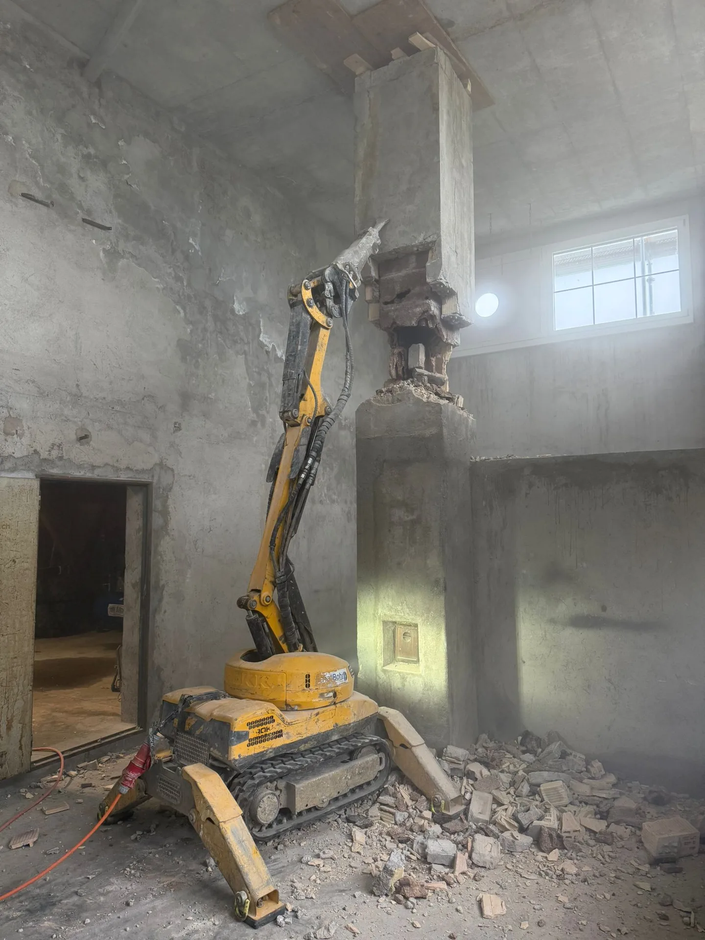 Abbrucharbeiten – Minibagger entfernt Betonstütze